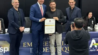 Giovanni Ballarin, CEO da Mestres, recebe o Diploma de Honra ao Mérito na ALESP durante cerimônia oficial de Empreendedor de Destaque 2026, ao lado de autoridades e convidados no Palácio 9 de Julho, em São Paulo.